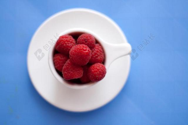 红色水果特写瓷杯中的红色树莓背景图片