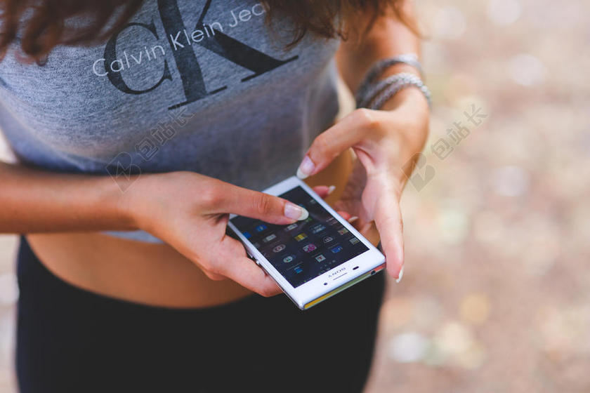 简约户外玩手机的女子背景图片