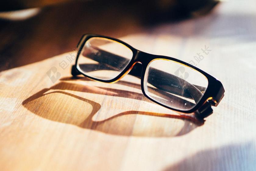 配件简约木板上阳光照射眼镜阴影特写背景图片