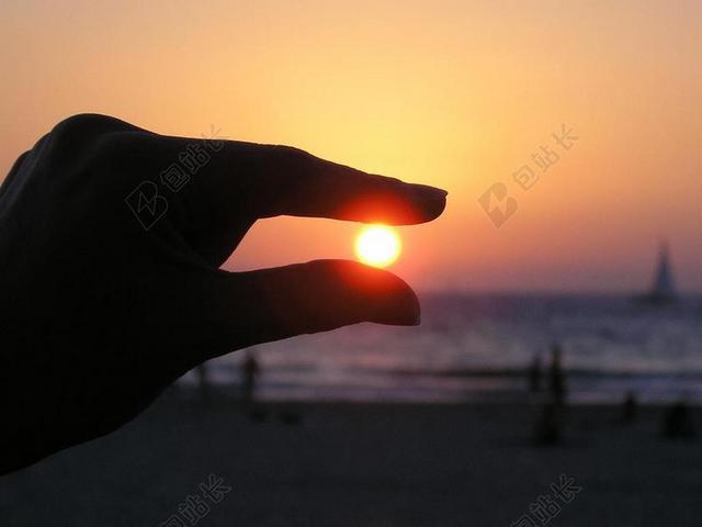 橙色天空文艺艺术海洋边日落手与落日的背景图片
