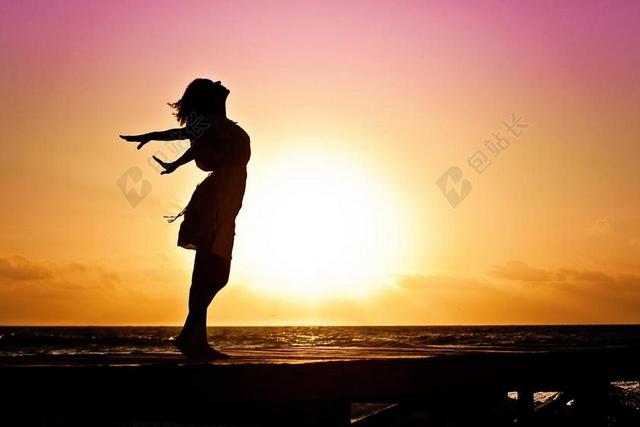 天空唯美文艺艺术海滩边黎明下穿连衣裙跳舞的少女剪影背景图片