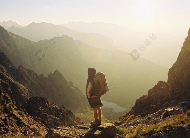黄色运动健美站在山上的背包客登山运动冒险背景图片