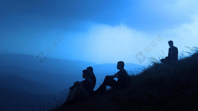 广告简约黄昏下坐在草地上的团队男性背景图片