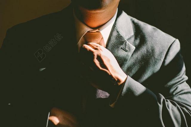黑色商务人士身着西装手系领带背景图片