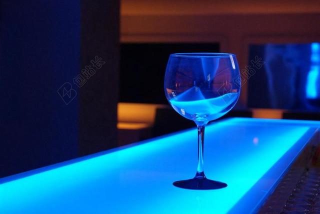 蓝色家居纹理蓝色桌子上的透明高脚杯背景图片