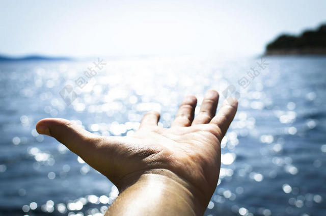 蓝色旅游度假一只手张开伸向大海手势背景图片