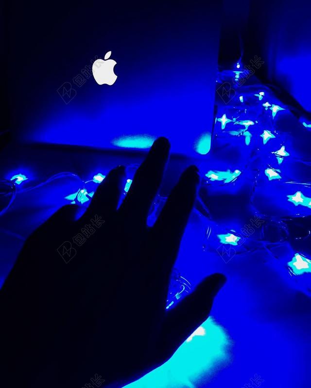 蓝色灯光照亮手触摸笔记本电脑背景图片
