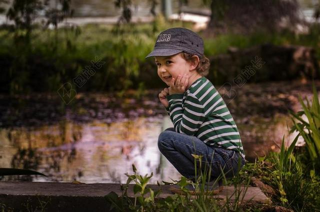 人开心池塘边微笑的男孩背景图片