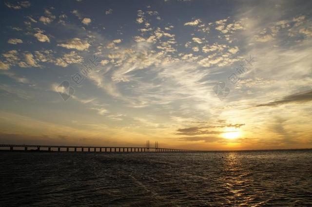 建筑夕阳下的大桥和海面背景图片