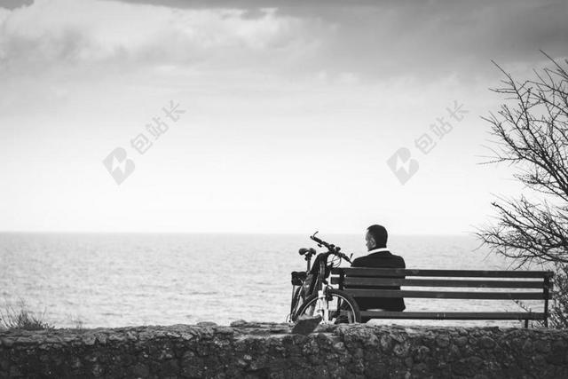黑白摄像人像海边沙滩男子长椅思考自行车背景图片