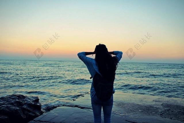 摄影人像取景海边石头日落夕阳女孩背影背景图片