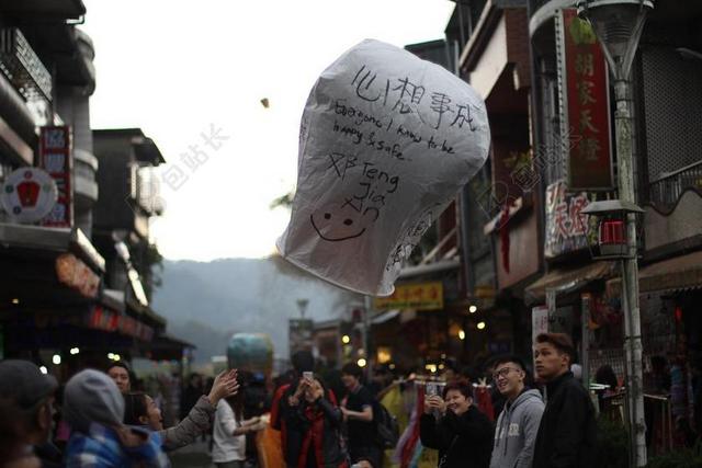 节日庆典街头行人放飞孔明灯祝福愿望飞行背景图片
