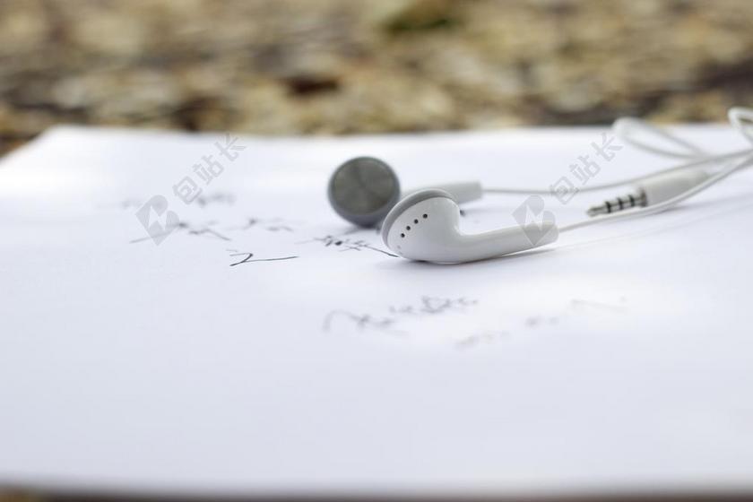 物品特写白纸上的歌词和耳机背景图片