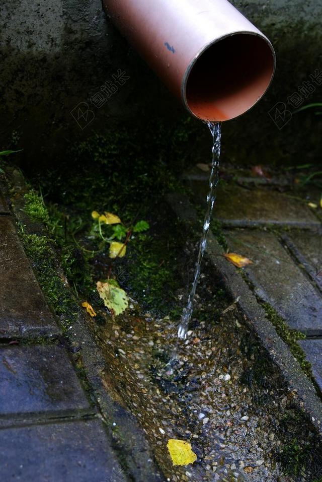 黑白水滴写实水管中流出的水到地面上出水水滴背景图片