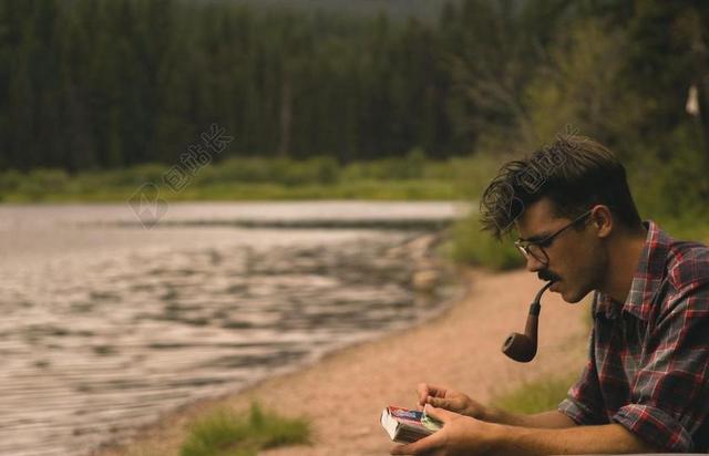简约户外抽烟斗的男子背景图片