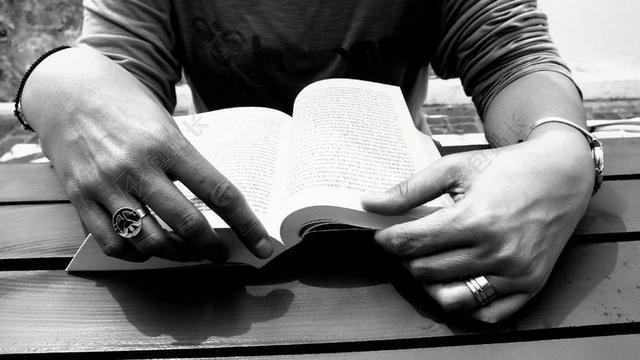 人户外桌子上看书的男人背景图片