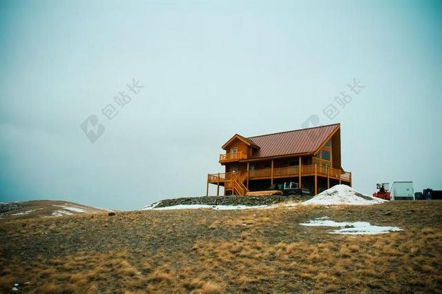 建筑山坡上的棕色木头房子背景图片