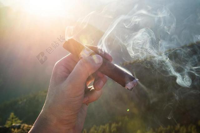 广告唯美夕阳下抽雪茄背景图片