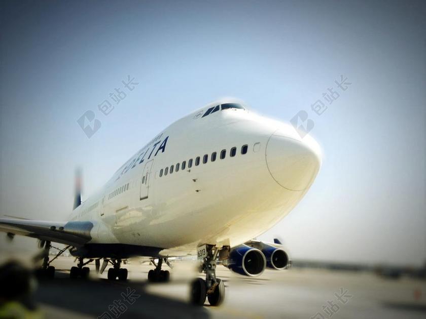 白色交通工具经典蓝天下的机场上的飞机机头近照飞机展示背景图片