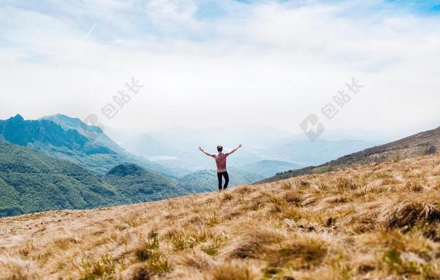 人背影草坡上欢呼的男人背景图片