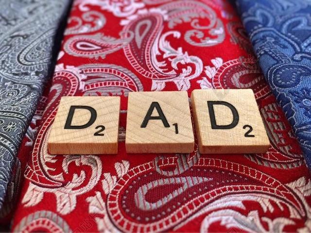 彩色摄影创意放在不同颜色布料上的DAD木头字块父亲亲子庆祝背景图片