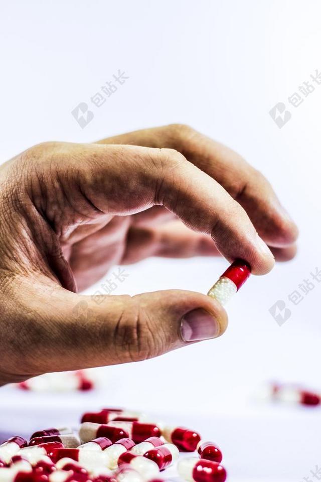 医疗手中的红色和白色药丸背景图片