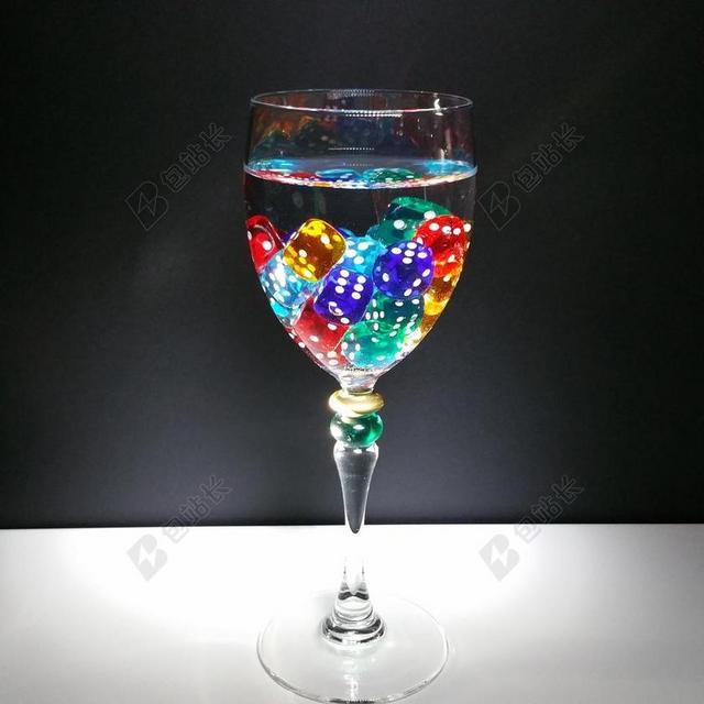 摄影创意高脚杯里的彩色骰子背景图片