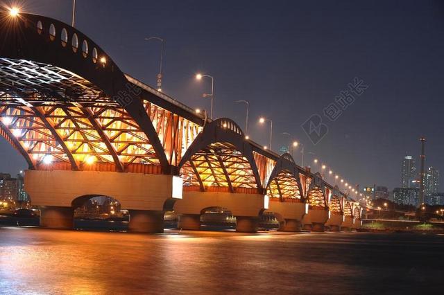 建筑夜景夜晚河面明亮的大桥背景图片
