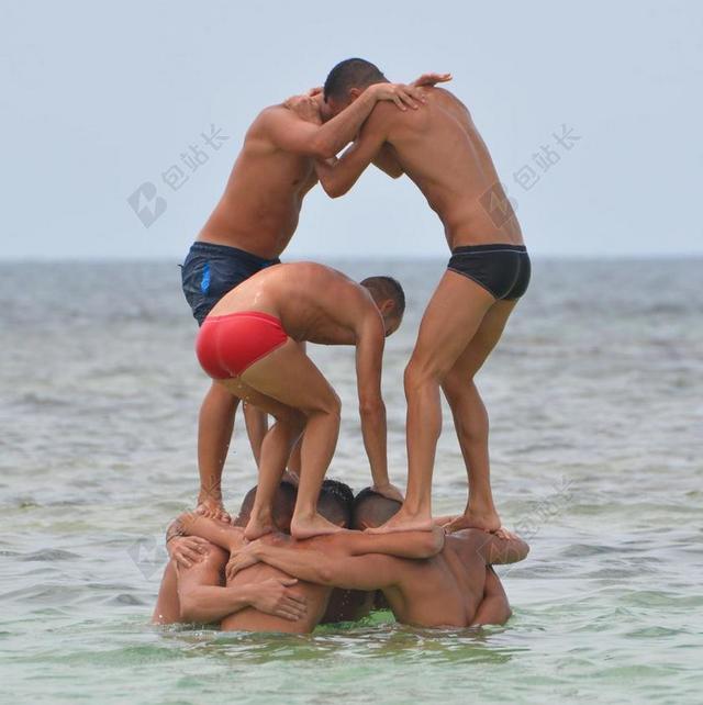 人海水中搭人塔的青年背景图片