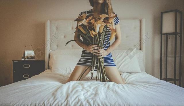 人浪漫床上拿花束的女人背景图片