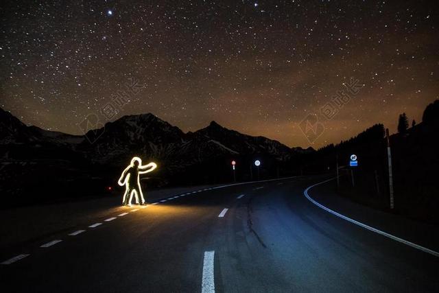 交通夜晚路边的人形彩灯背景图片