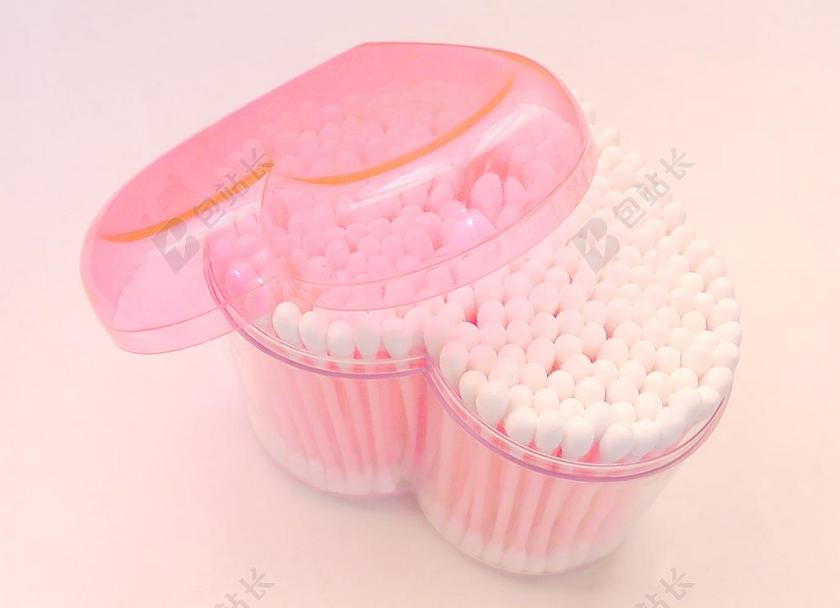 白色医疗清新装在桃心透明盒子里面的医用棉签背景图片