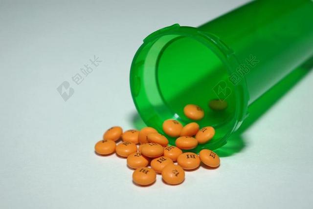 医疗绿色的药瓶和黄色的药丸背景图片
