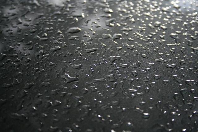 静物黑色表面的雨滴背景图片