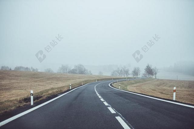 灰色道路无尽云雾下的原野边的公路道路设计背景图片