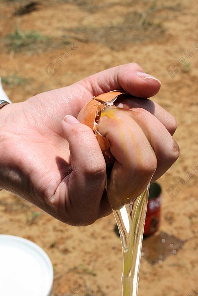 食物破碎男子捏碎一只鸡蛋浪费食物背景图片