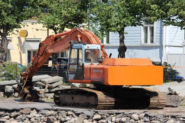 机械经典路面上作业的橙色挖土机机械施工背景图片