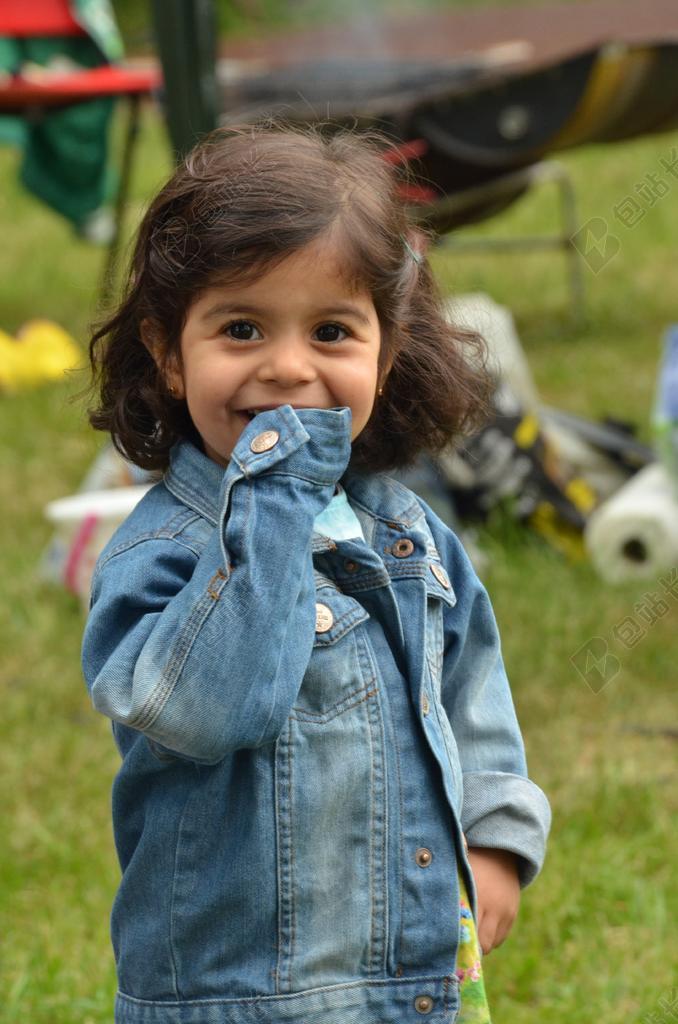 人物可爱草地微笑的女孩儿童户外摄影背景图片