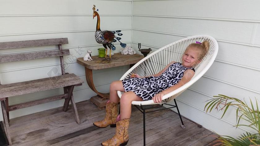 人像摄影女孩儿童躺椅小花园户外舒适开心背景图片