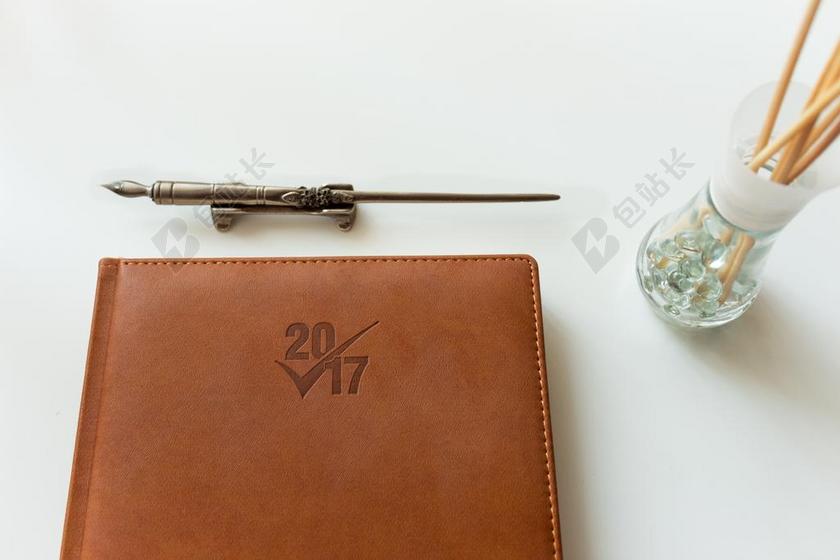 白色物品复古皮本子和复古钢笔背景图片