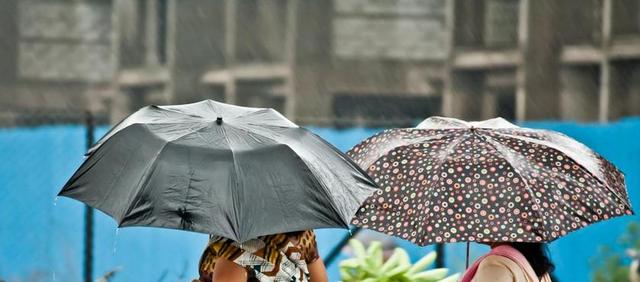 现代城市下雨雨伞打伞人背景图片