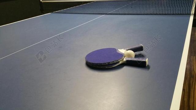 物品蓝色乒乓球球桌上的球拍背景图片