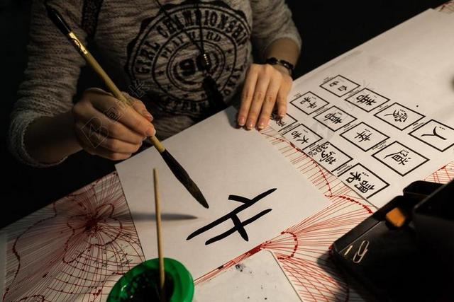日本老人演示毛笔书法背景图片