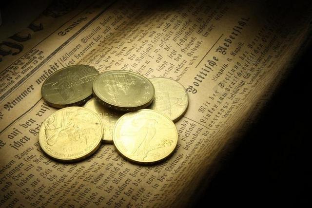 金融报纸上的金属硬币背景图片
