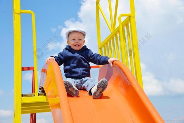 游乐园玩耍玩滑梯男孩背景图片