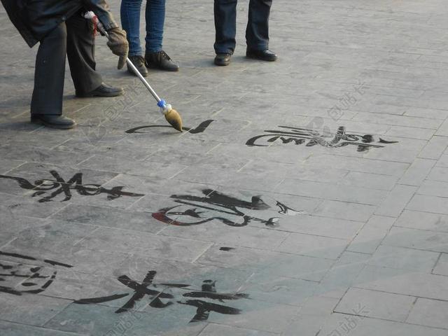 在地上写字的老人背景图片