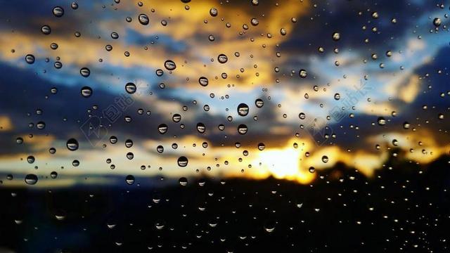 日落夕阳玻璃雨滴水珠模糊色彩背景图片