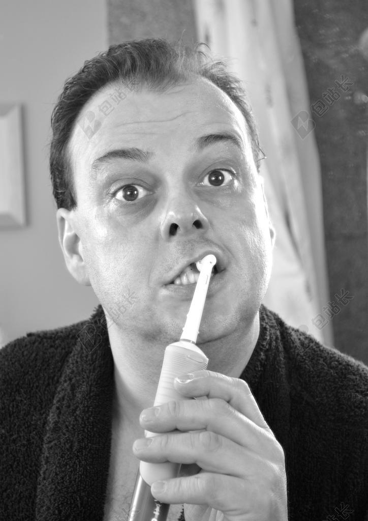 黑白喜剧演员黑色浴袍电动牙刷刷牙拍摄背影图片