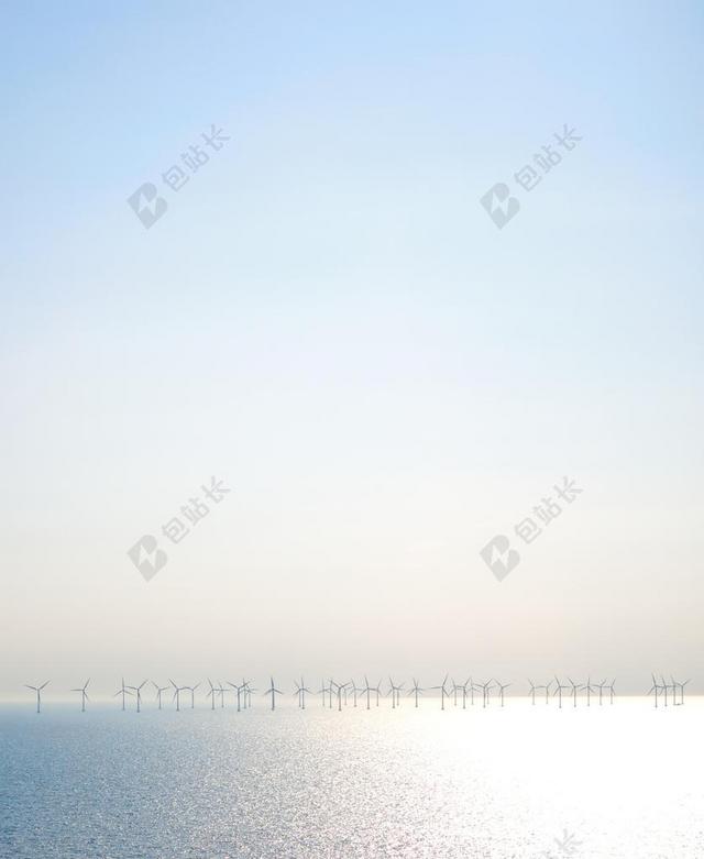 浅蓝色大海风力发电一列风车在大海中背景图片
