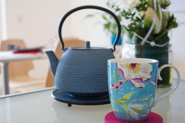 蓝色茶壶茶杯色彩丰富花朵桌上植物背景图片